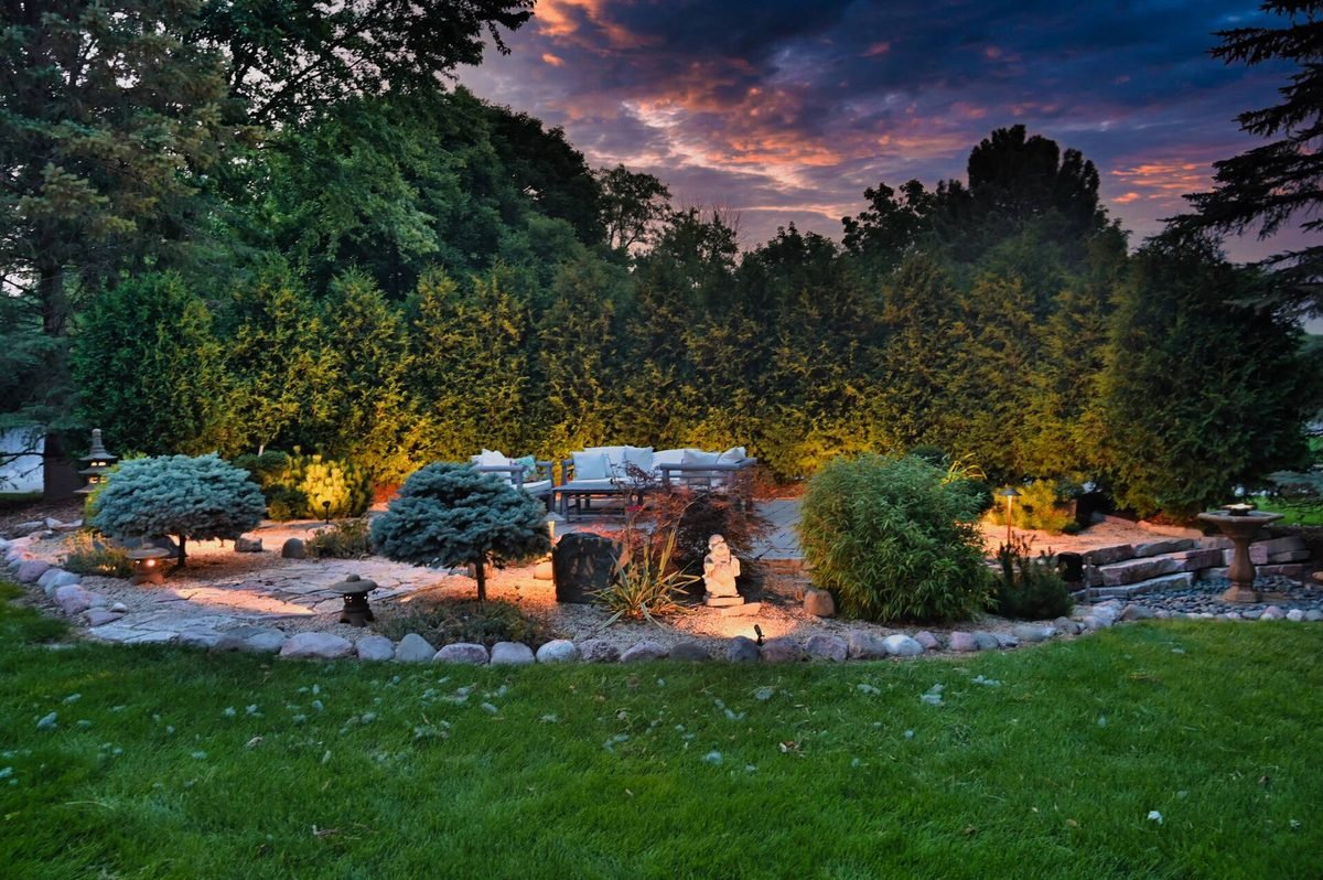 Garden seating area with path and accent lights at dusk
